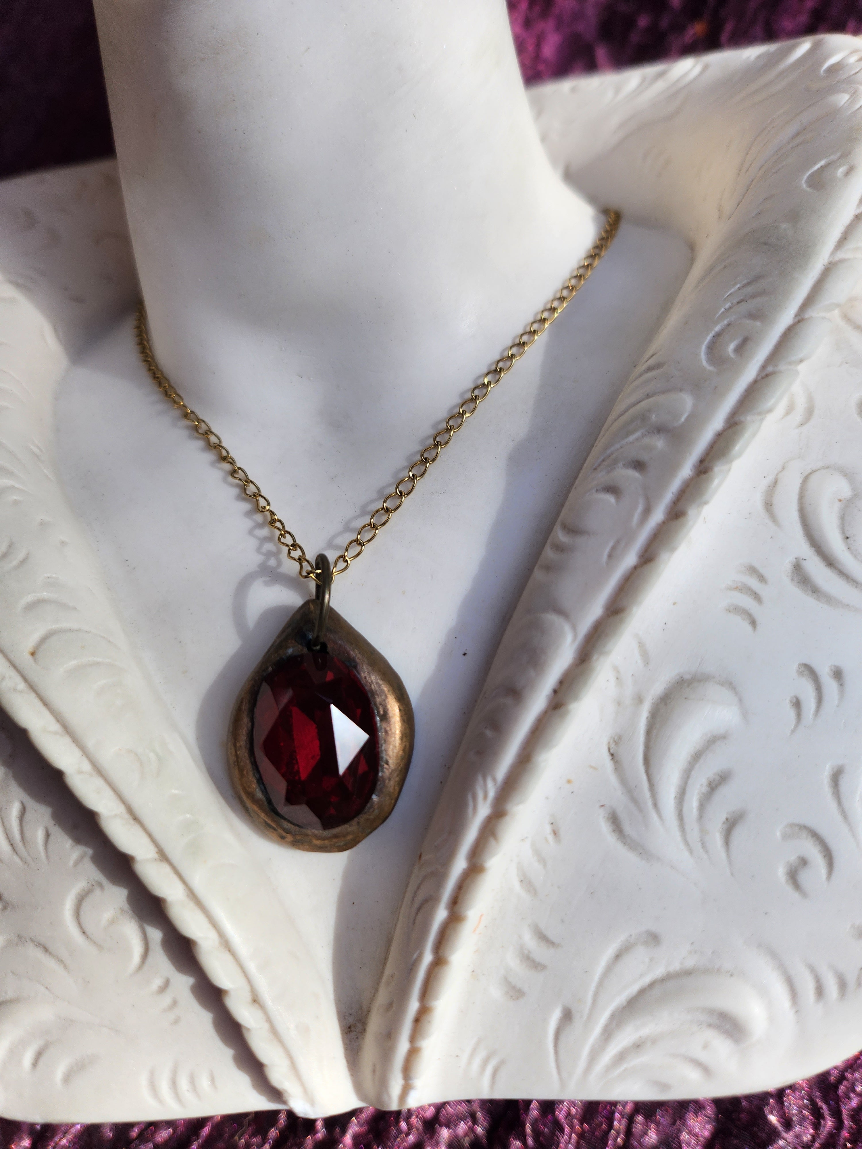 Colgante de bronce hecho a mano con cristal rojo intenso.