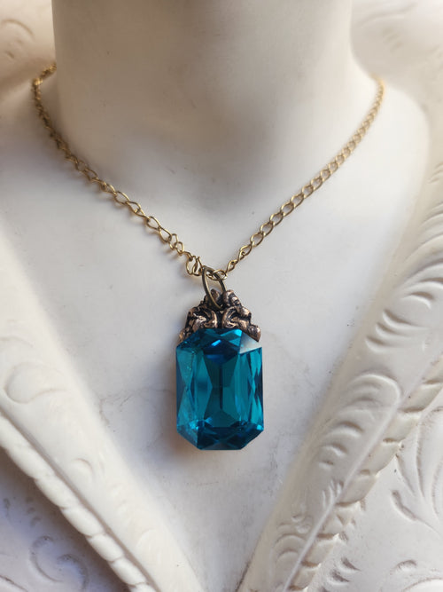 Colección Resonancia Arcana – Dije de bronce hecho a mano con cristal octogonal azul eléctrico