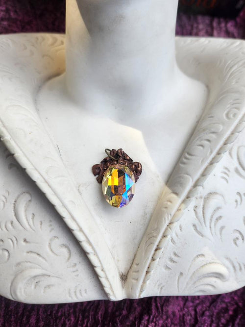 Colección Resonancia Arcana – Colgante de cobre hecho a mano con cristal ovalado iridiscente.