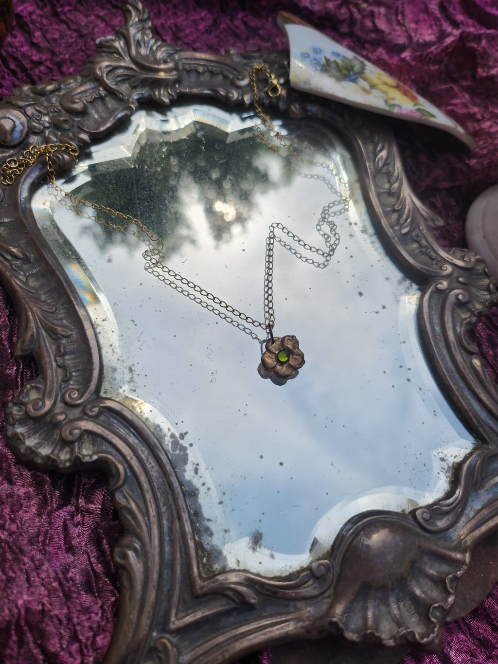 Colección Eternal Bloom – Colgante de flor de bronce hecho a mano con cristal verde.