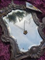 Colección Eternal Bloom – Colgante de flor de bronce hecho a mano con cristal verde.