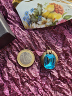 Colgante de bronce hecho a mano con cristal azul.