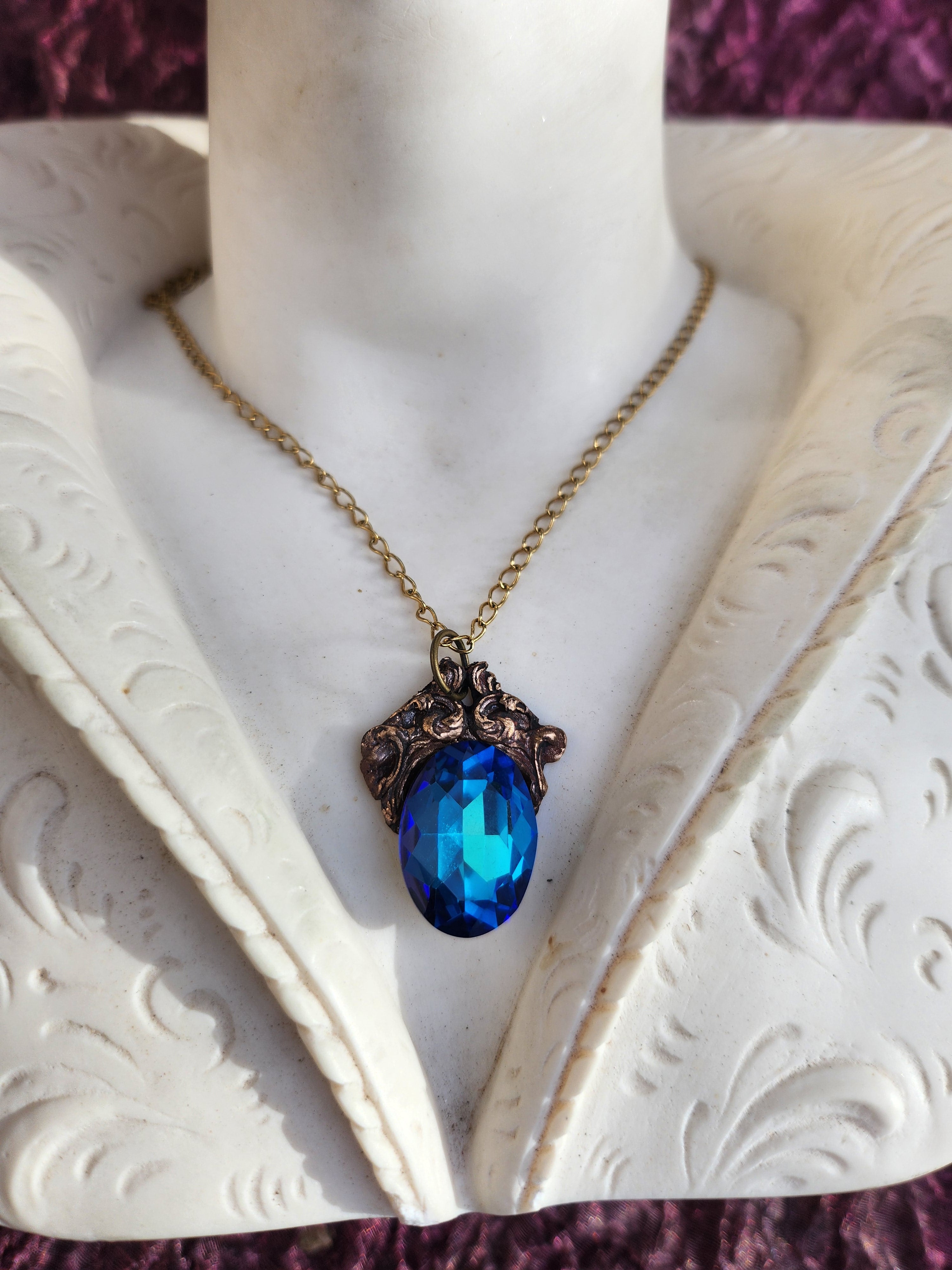 Colección Resonancia Arcana – Colgante de bronce hecho a mano con cristal ovalado azul.