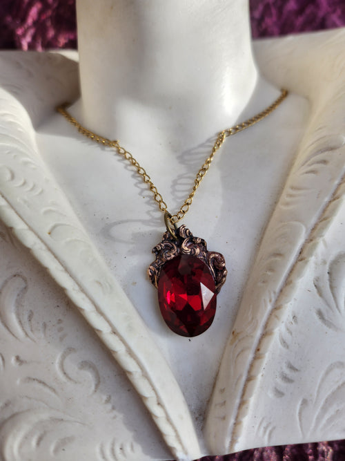 Colección Resonancia Arcana – Colgante artesanal de bronce con cristal ovalado rojo rubí