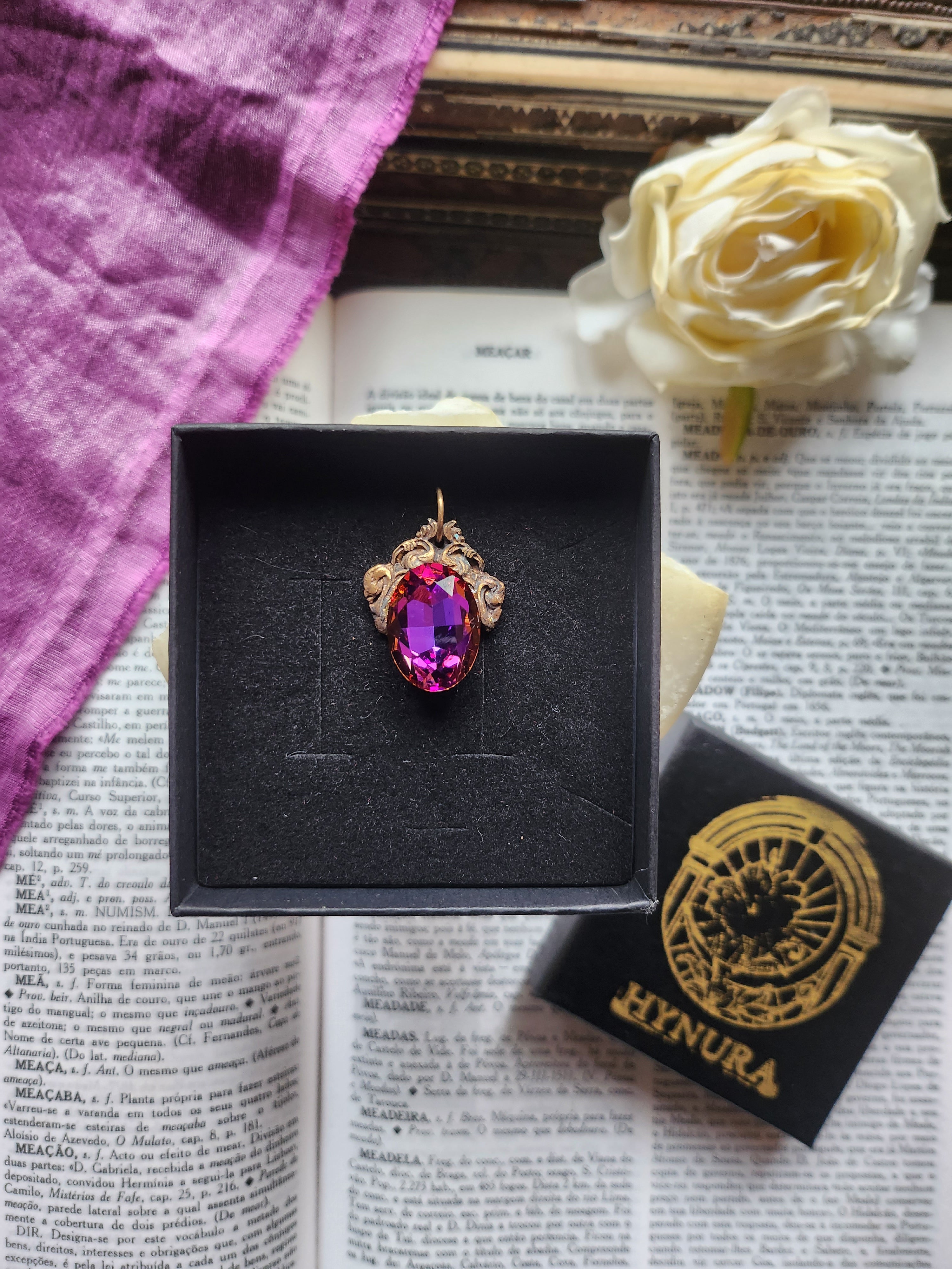 Coleção Ressonância Arcana – Pendente artesanal em bronze com cristal oval nas cores roxo, fúcsia e âmbar.