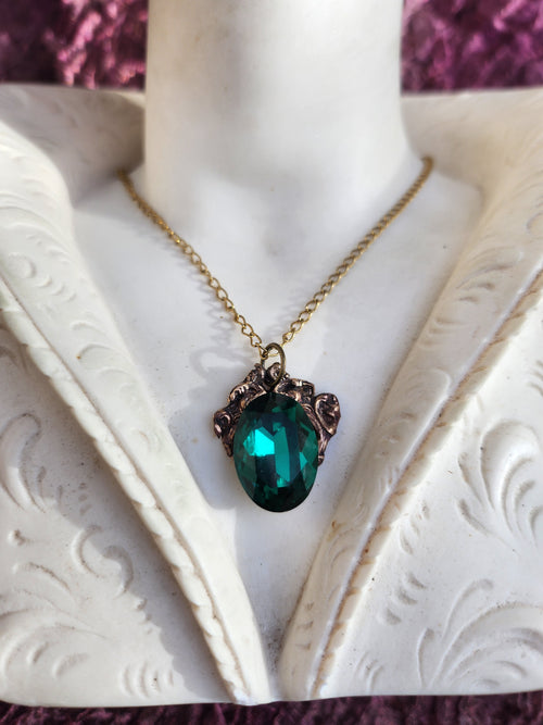 Colección Resonancia Arcana – Colgante artesanal de bronce con cristal ovalado verde esmeralda.