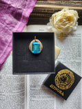 Colgante de bronce hecho a mano con cristal azul.