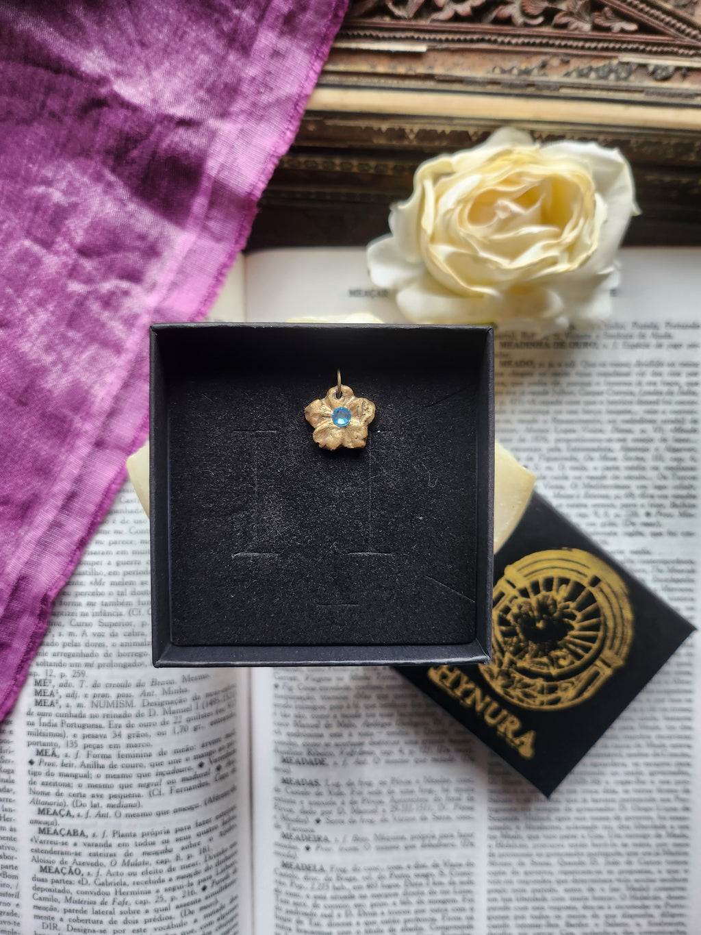 Colección Eternal Bloom – Colgante de flor de bronce hecho a mano con cristal azul claro.