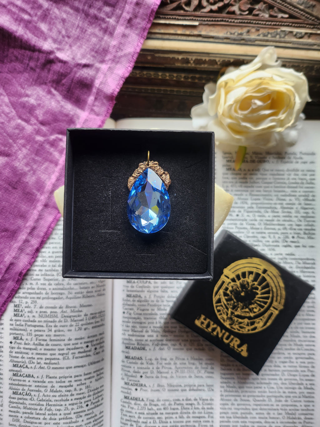 Coleção Barroca Mística – Pendente artesanal em bronze com cristal azul claro em forma de lágrima.